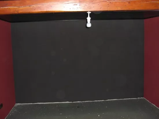Schwarze Wand, an welcher die Rahmenleinwand befestigt wird.